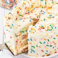 A close up of a slice of Funfetti Layer Cake being removed from the cake.