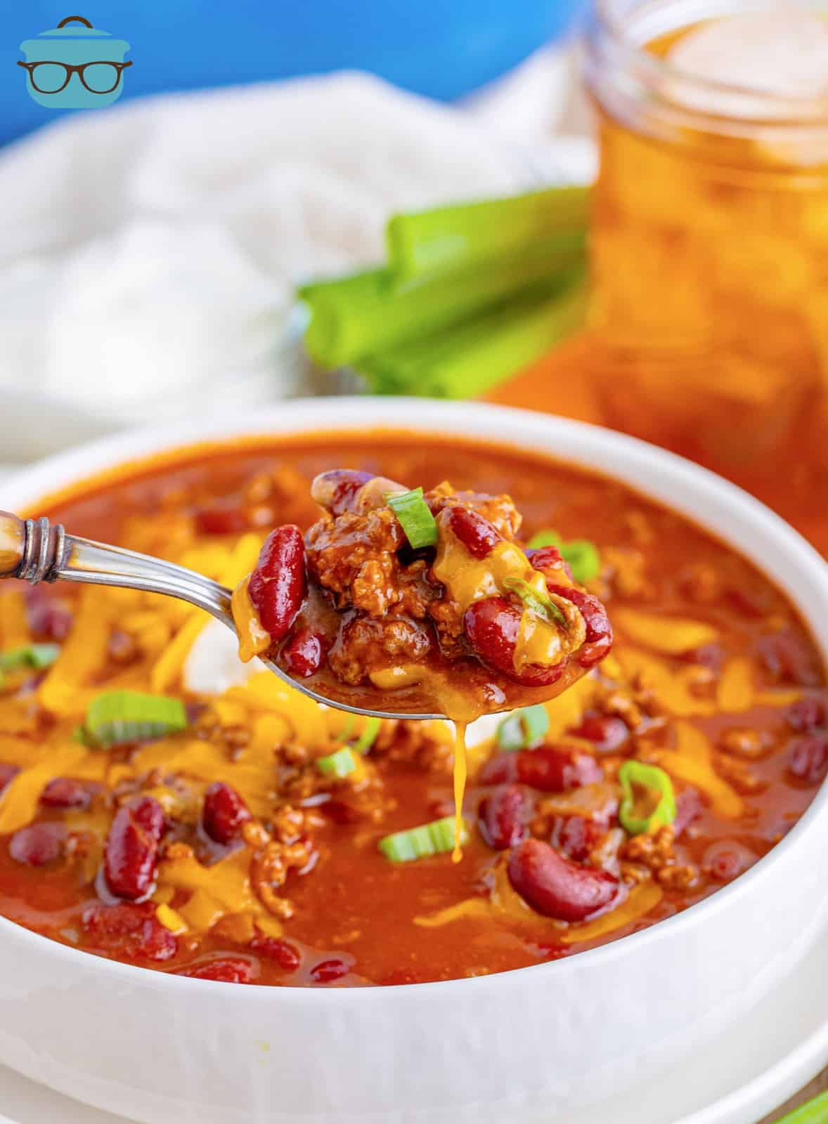 A bowl of Cafeteria Chili holding a bite of chili above. 