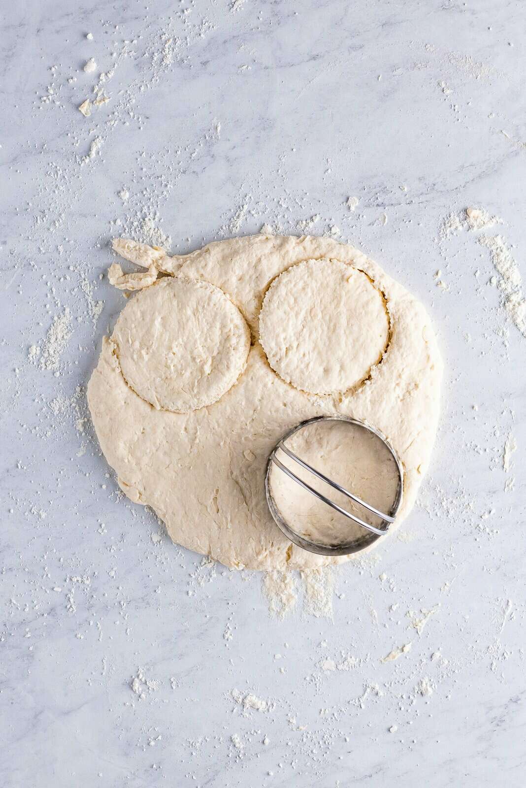 Biscuit dough with cutter cutting out dough. 