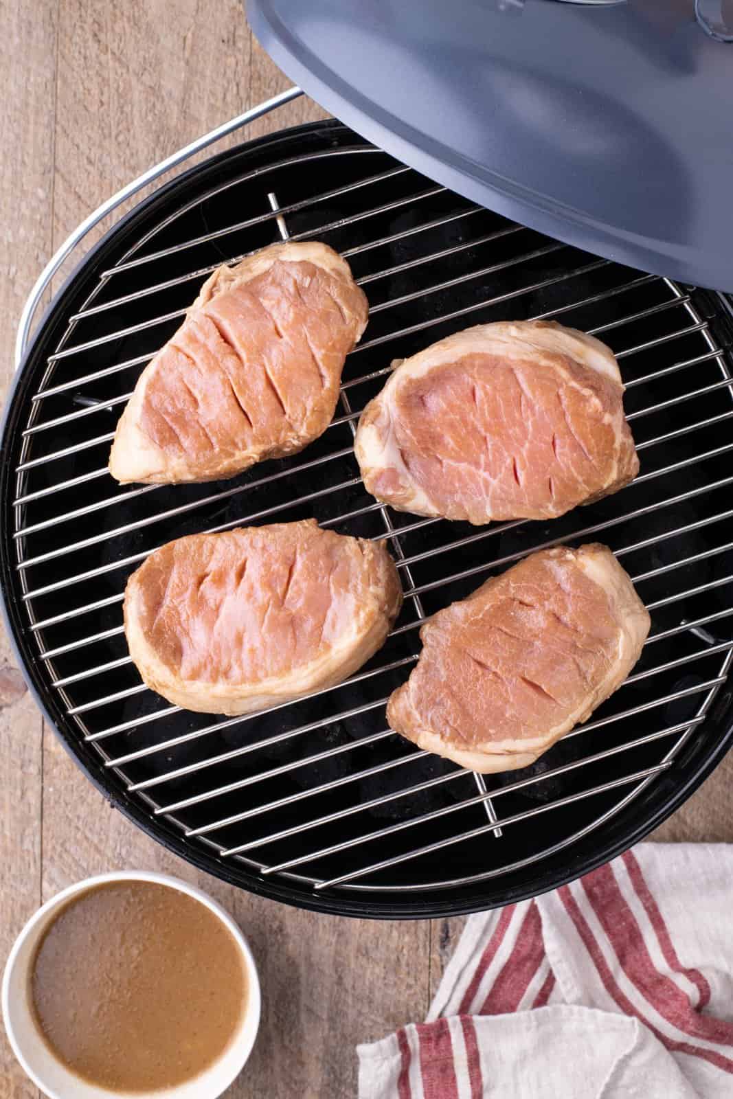 Marinated pork chops on grill.