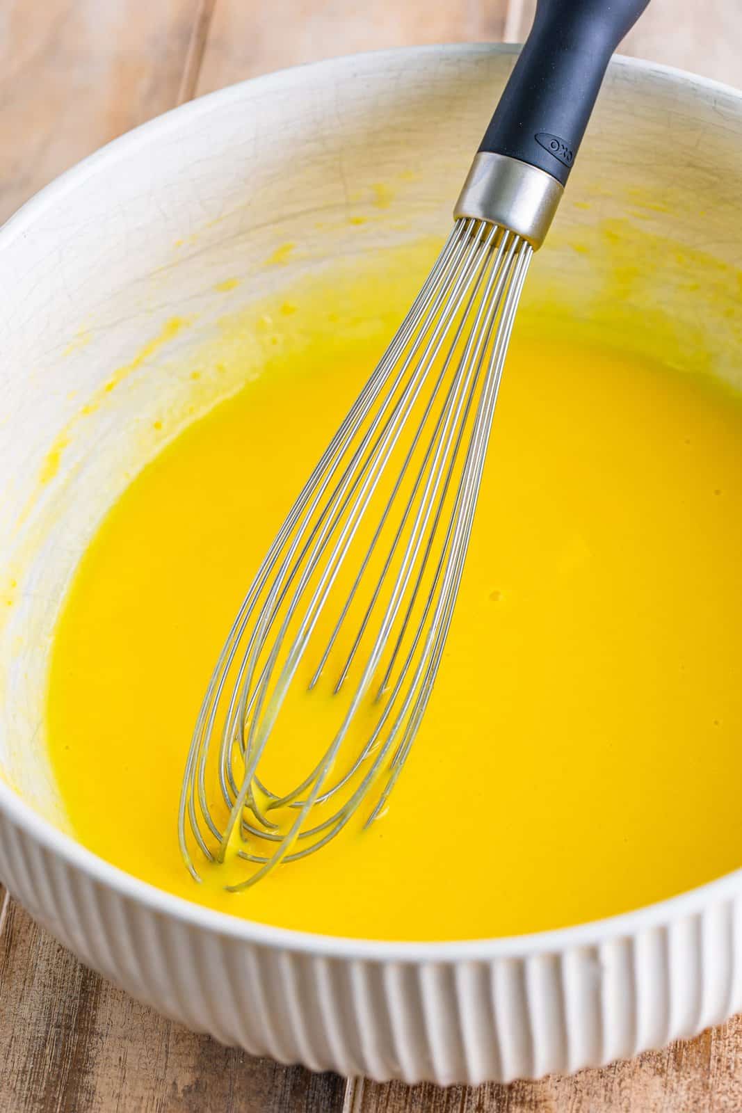 Vanilla pudding in a bowl being whisked.