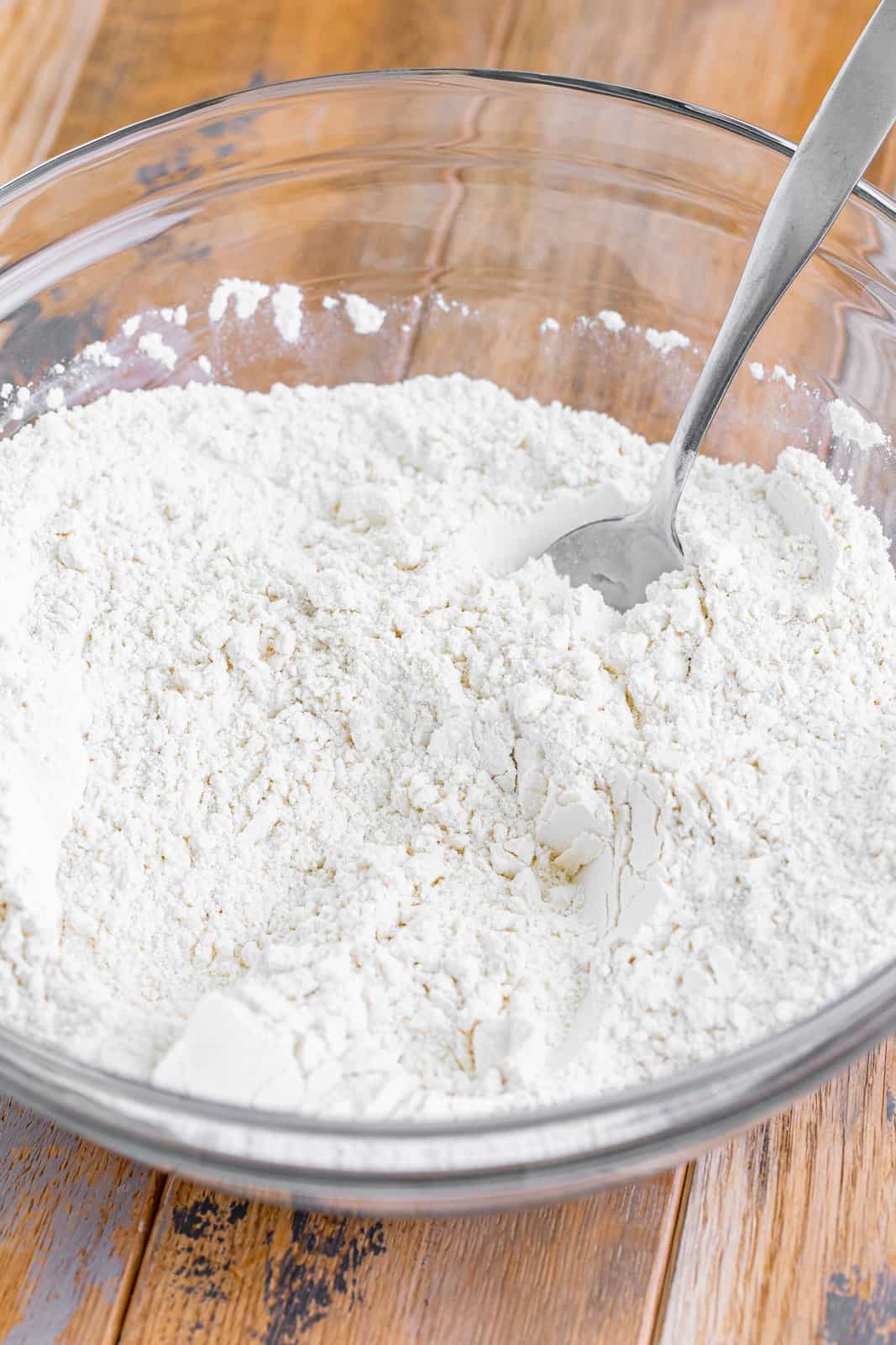 A mixing bowl with flour, sugar and baking powder.