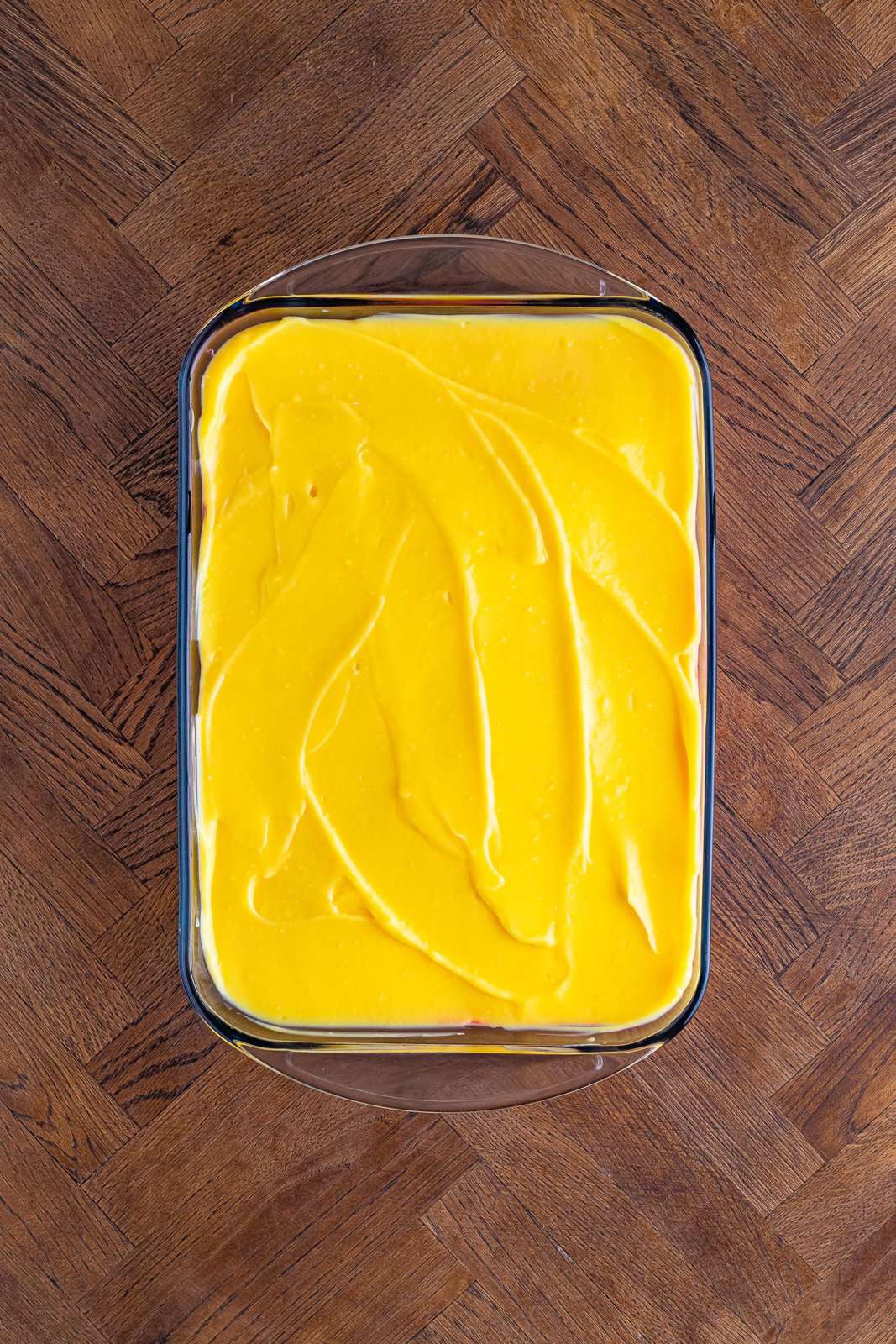 Vanilla pudding layer smoothed out over top in a baking dish.