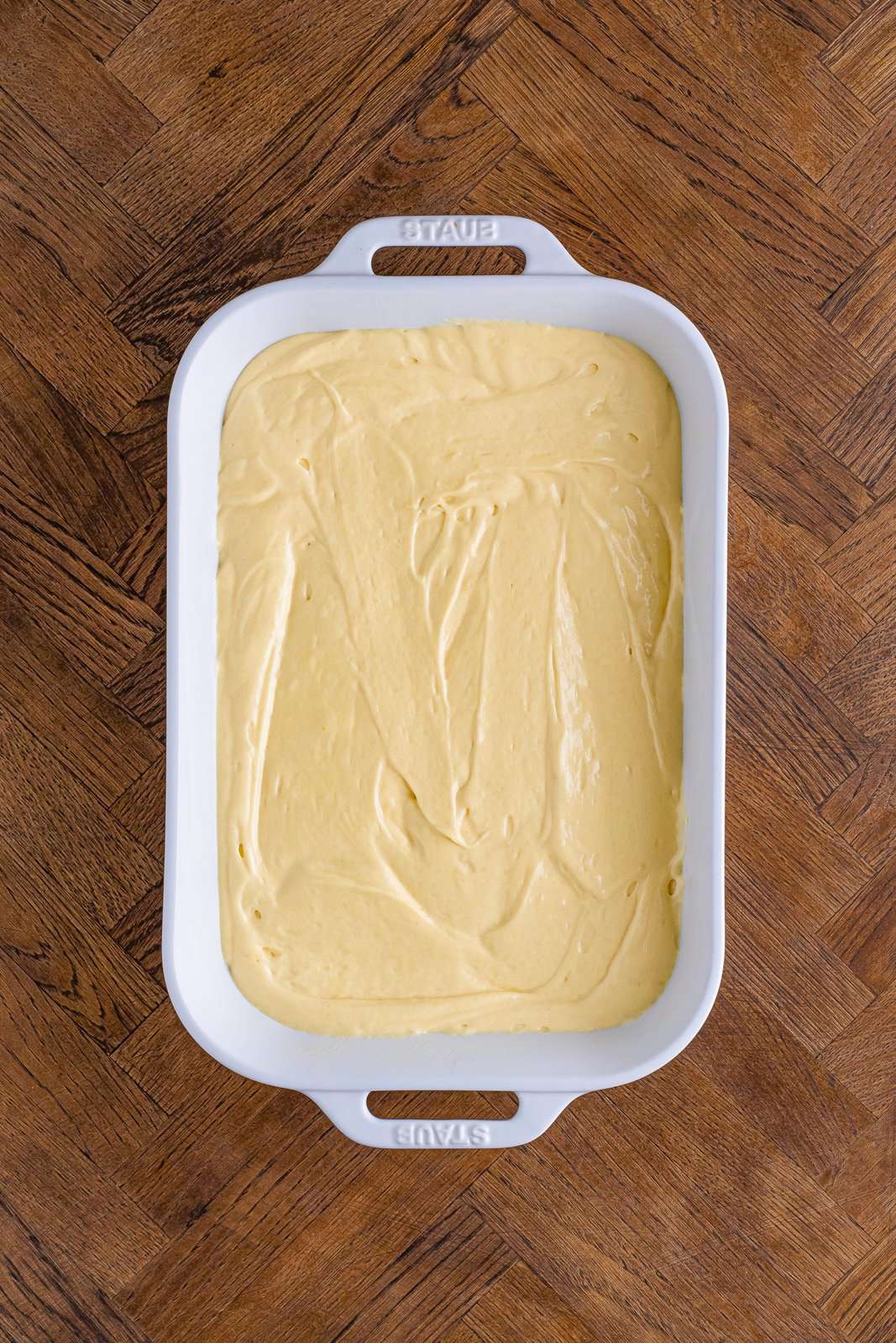 Baking dish with yellow cake mix batter from scratch.