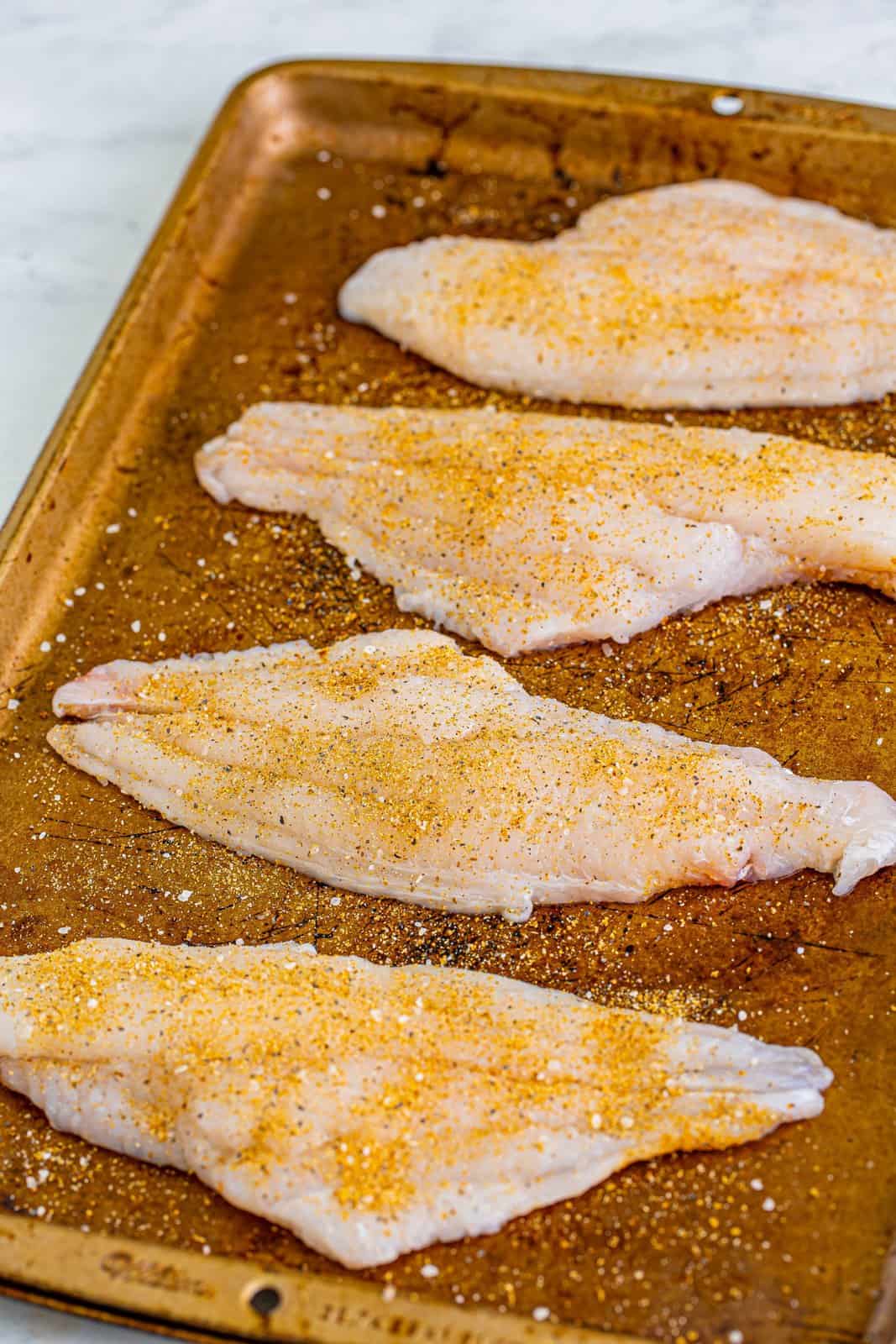Catfish filets with garlic powder, onion powder, salt, and black pepper.