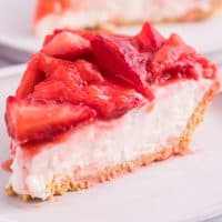Close up looking at a piece of Strawberry Cream Cheese pie with fresh strawberries on top.