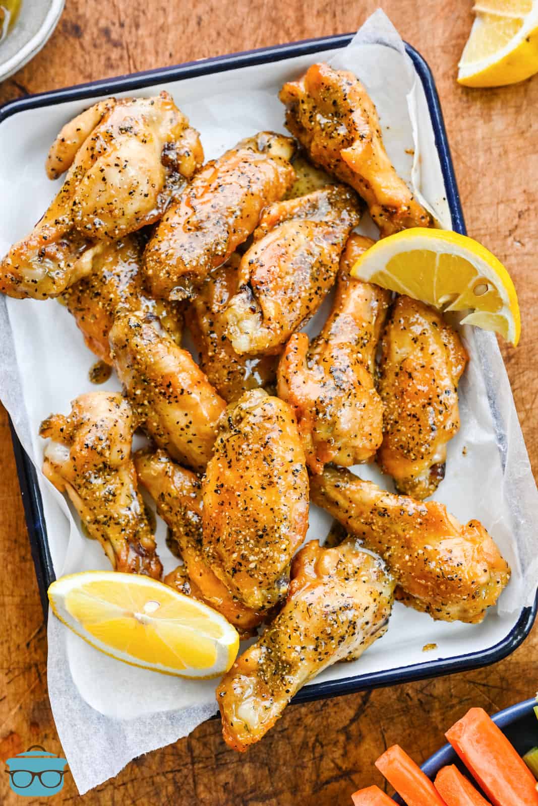 Looking down on a baking sheet with parchment paper and fresh baked lemon pepper chicken wings.
