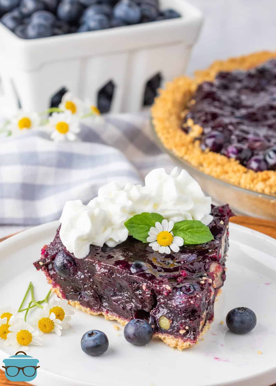 A plate with a slice of Blueberry Jell-O Pie with whipped cream on top.