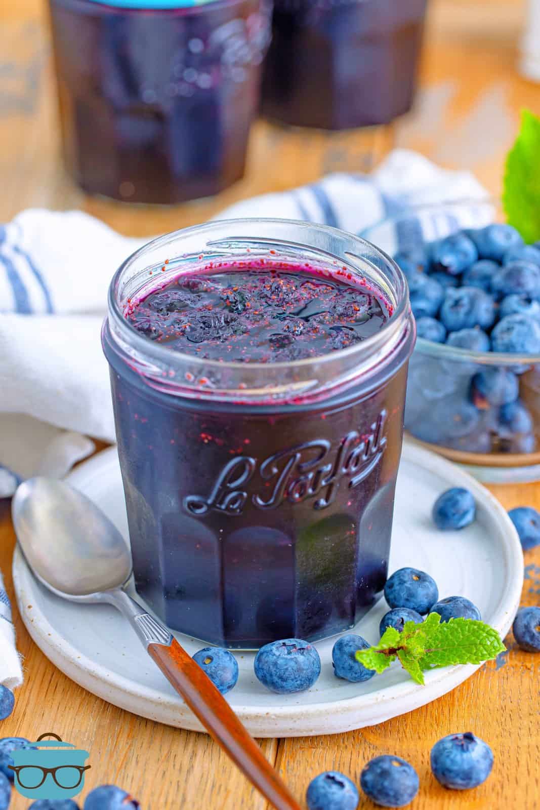 A jar of homemade blueberry jam on a plate.