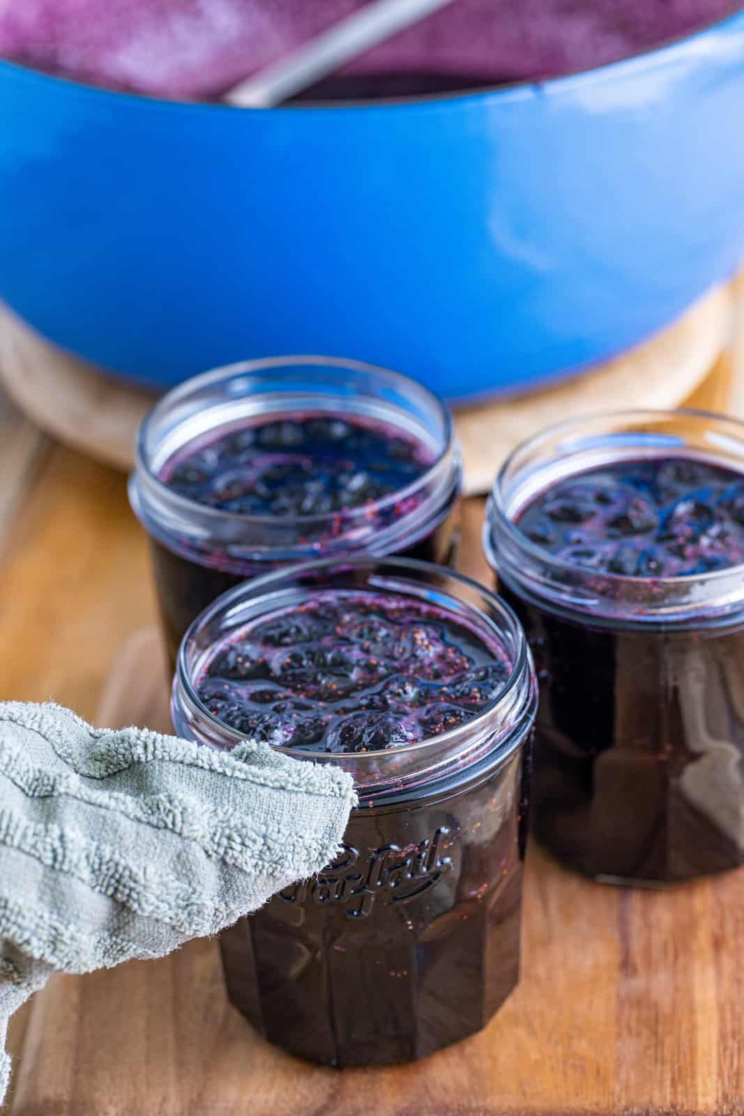 Wiping off the edge of a blueberry jam jar.