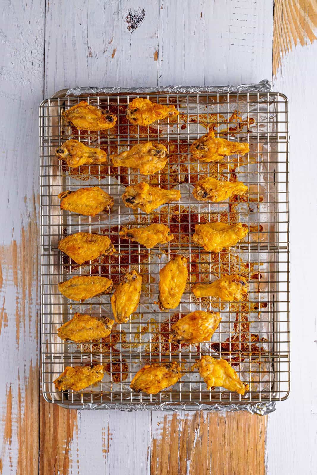 A wire rack with seasoned baked chicken wings.