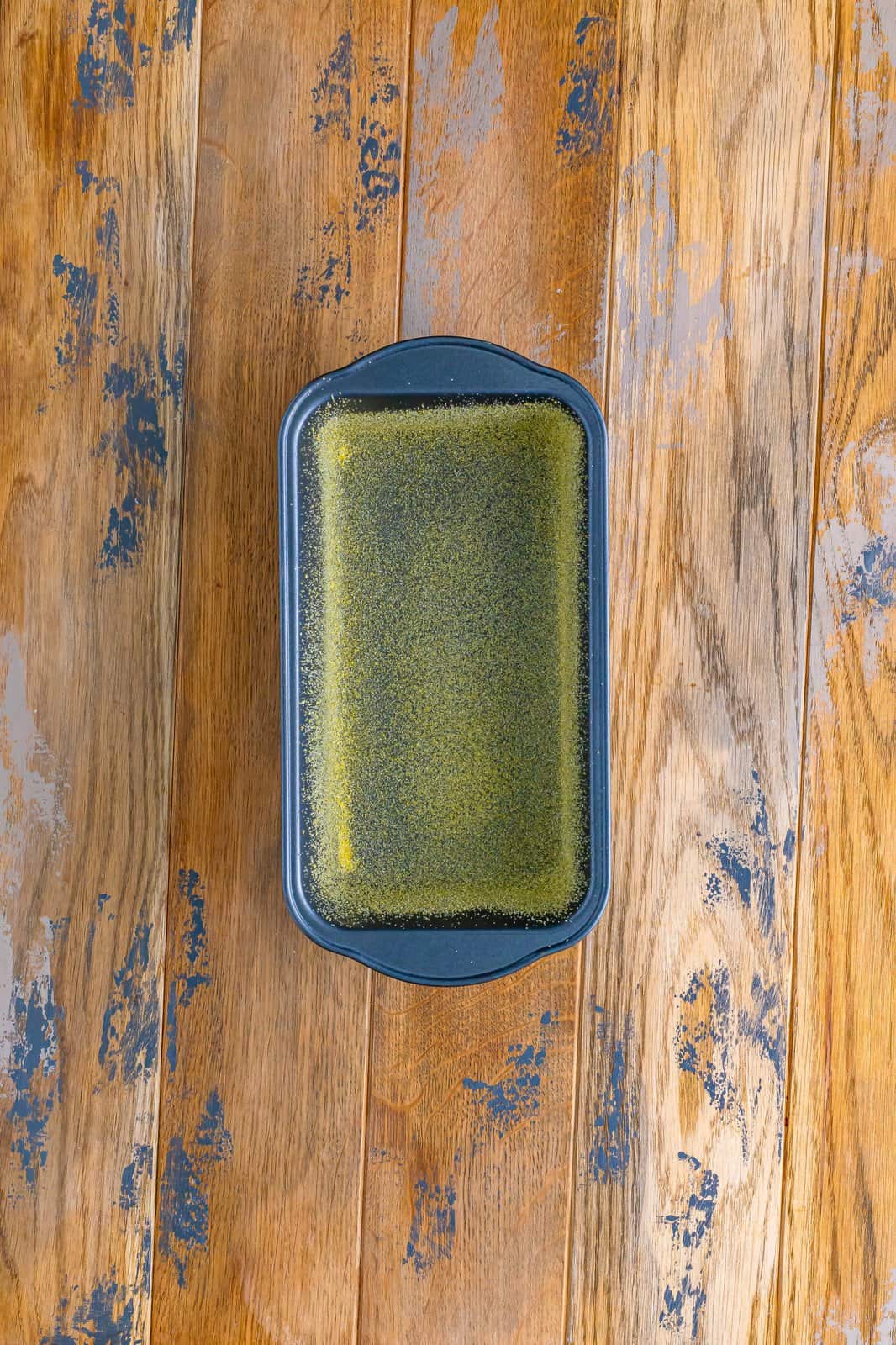 cornmeal in the bottom of a metal loaf pan.