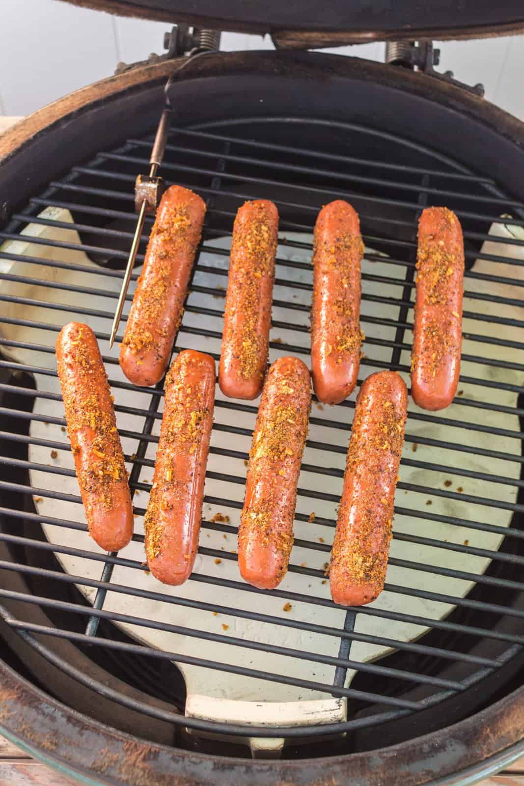 Seasoned hot dogs placed directly on a grill grate. 