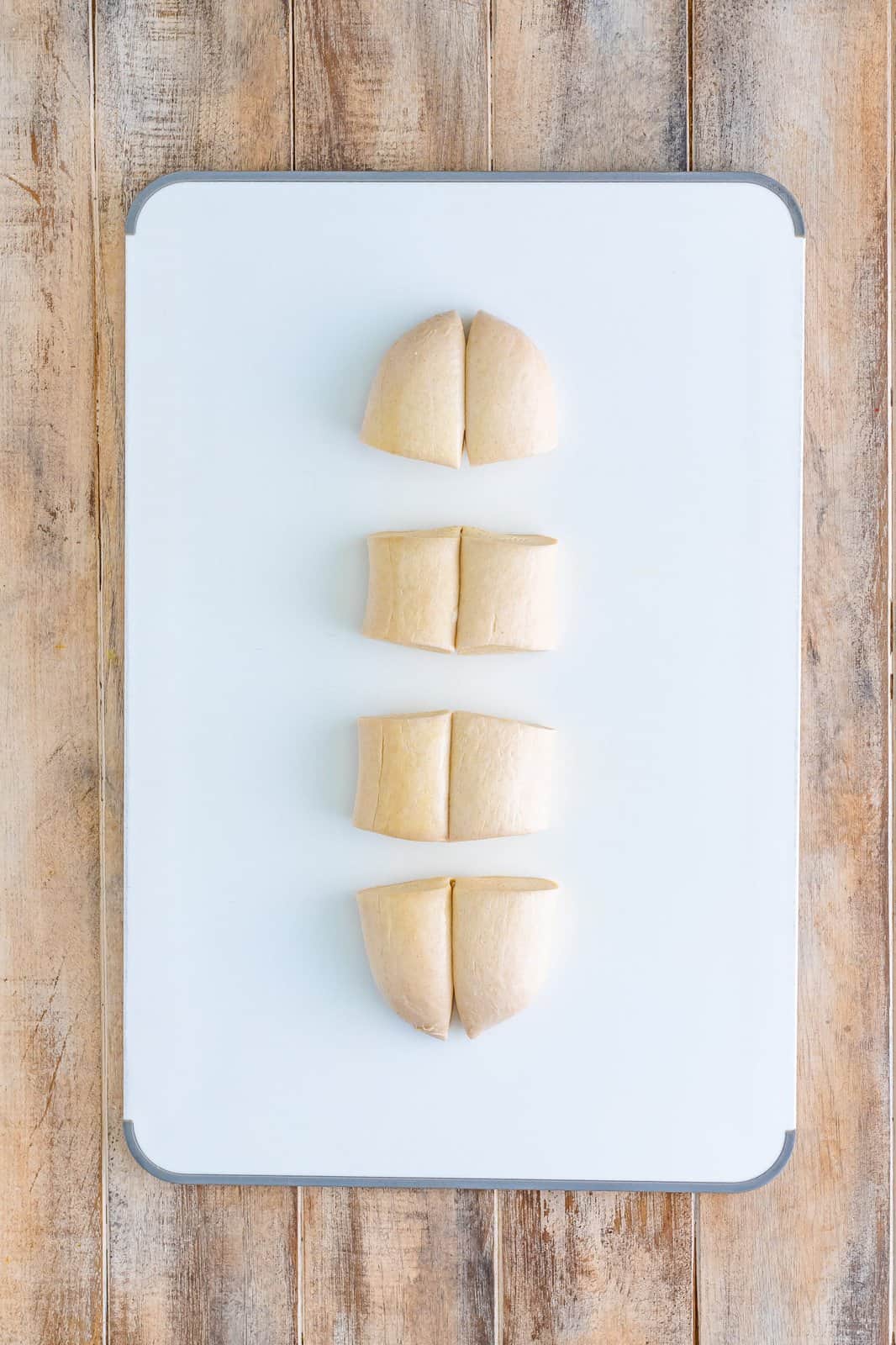 Bread dough cut into 4 pieces with two sections each.
