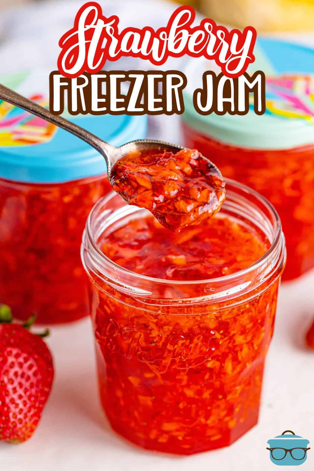 A jar of homemade strawberry freezer jam with a spoon.
