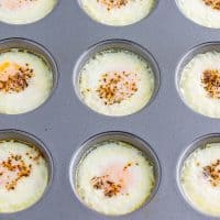 A muffin tin with baked egg mixture in each capsule.