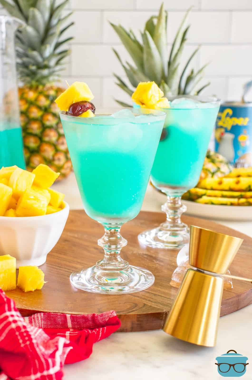 Two Blue Hawaiian cocktails with garnishes.