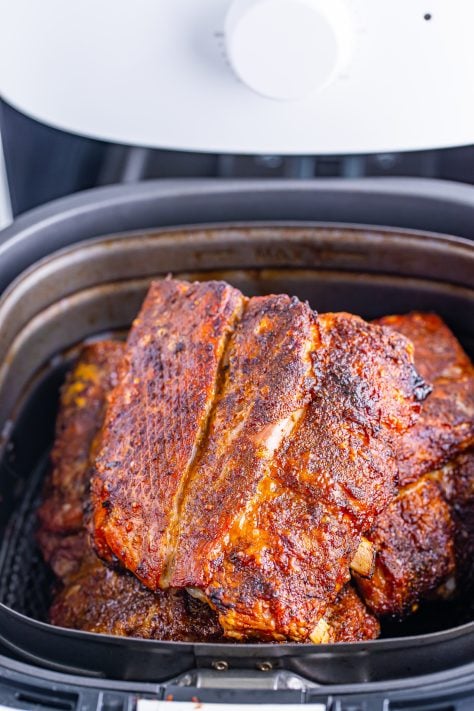 fully cooked rib sections in the air fryer basket.