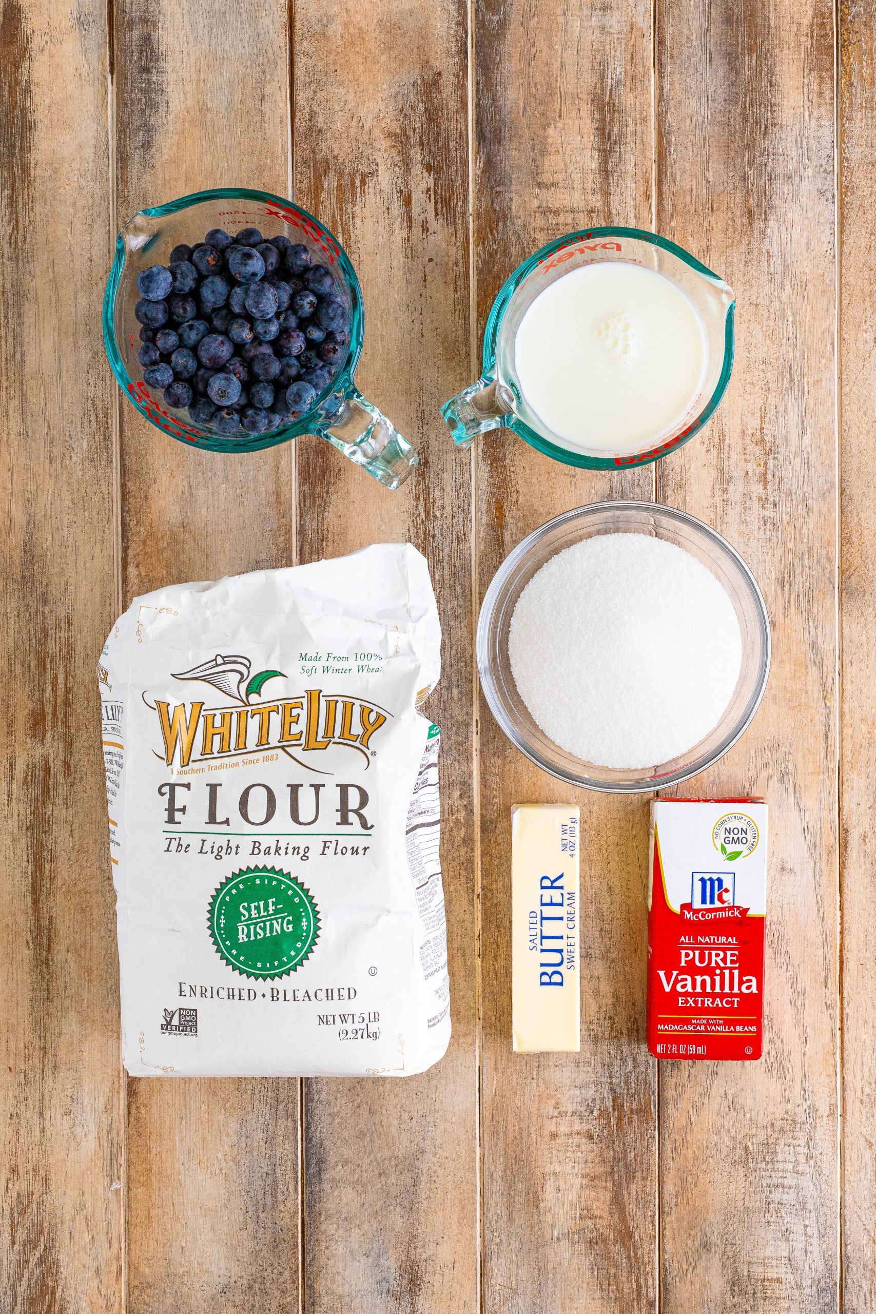 blueberry cobbler ingredients: self-rising flour, sugar, milk, salted butter, vanilla extract, fresh blueberries.
