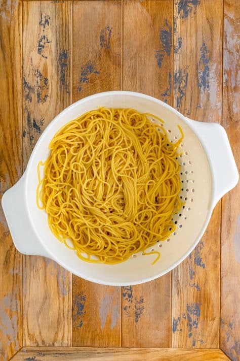 Cooked spaghetti pasta in a strainer.
