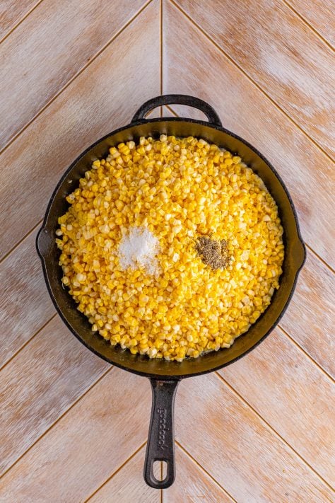 Butter, salt, pepper, and corn in a cast iron skillet.