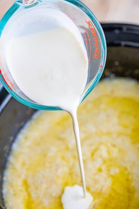 Heavy cream being poured in grits.
