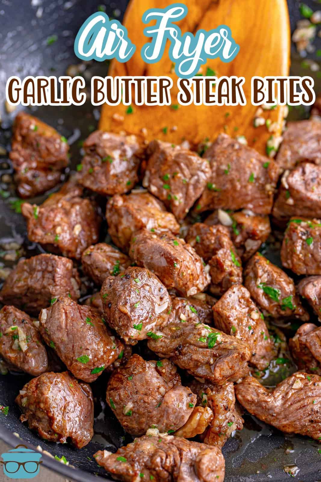 A wooden spoon pushing the Garlic Butter Steak Bites in a pile.