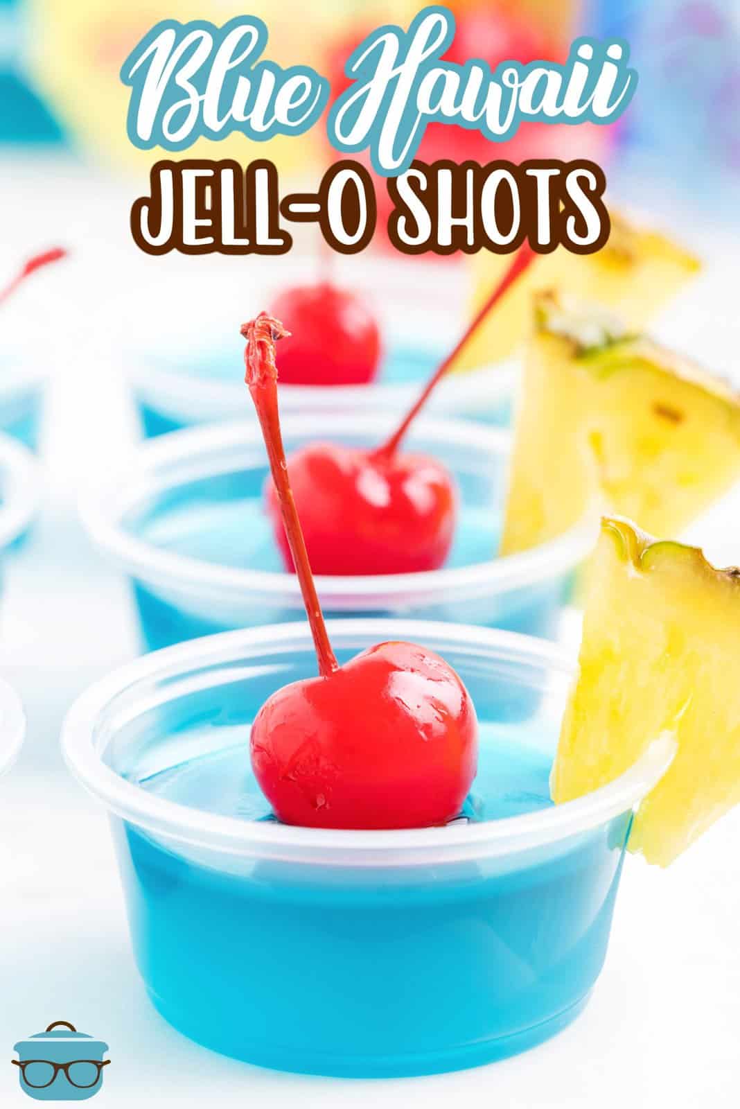 A couple pineapple and cherry garnished Blue Hawaii Jell-O Shots.