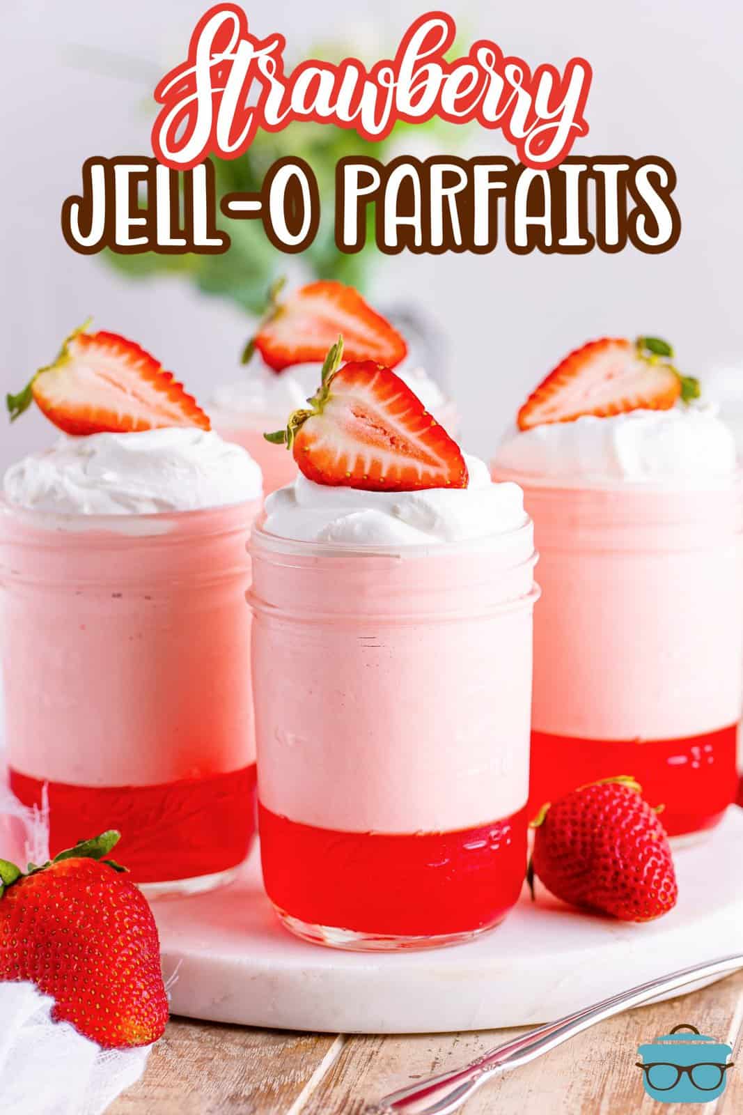 A few strawberry Jell-O parfaits sitting on a serving tray.