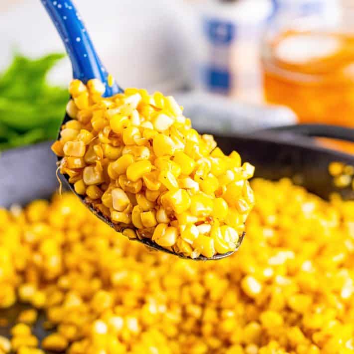 A spoon of Fried Corn over the skillet full.
