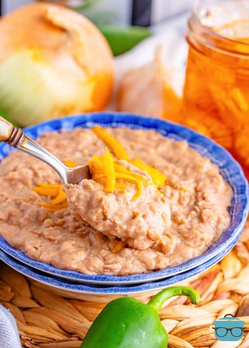 A bowl of refried beans with a spoon picking up some.