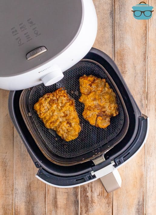 Looking down into the basket of an Air Fryer with Chicken Fried Steak pieces.