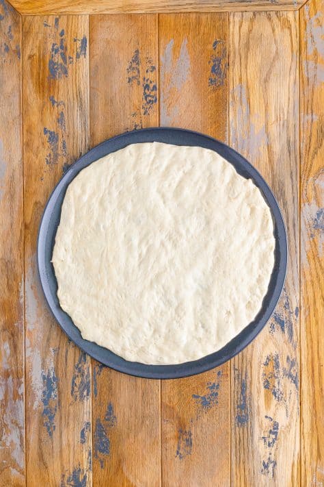 Pizza dough on a pizza pan.