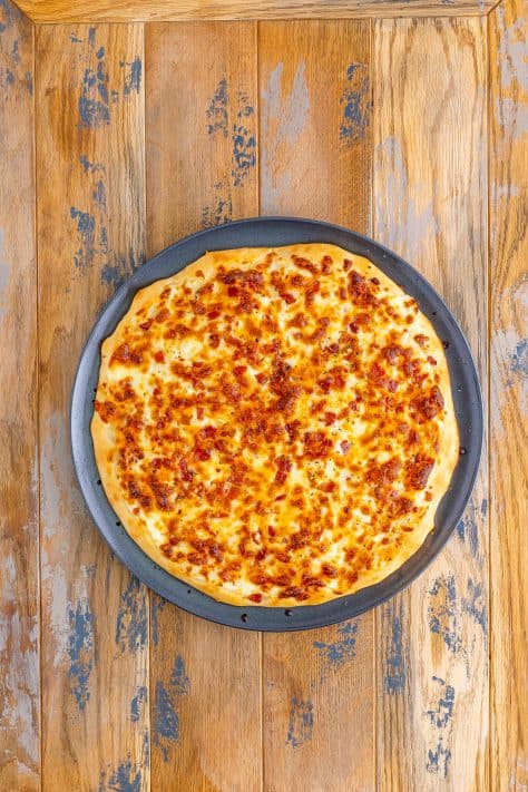 A baked blaze pizza on a pizza pan.