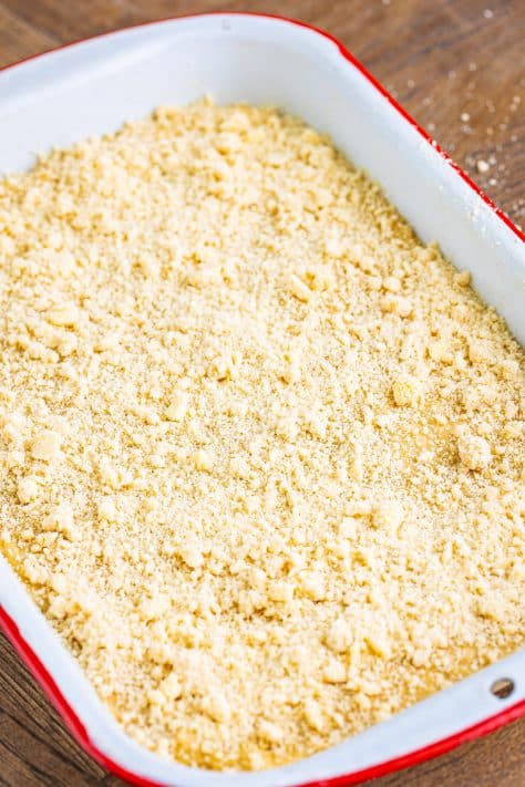Crumb mixture on top of the bread batter in a baking dish.