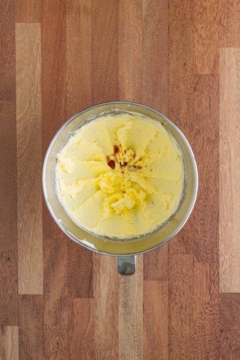 A mixing bowl with butter, sugar and vanilla extract.