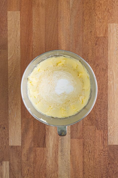 A mixing bowl with butter, sugar, vanilla extract, flour and baking powder