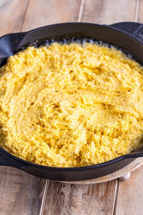 Cornmeal batter in a cast iron skillet.