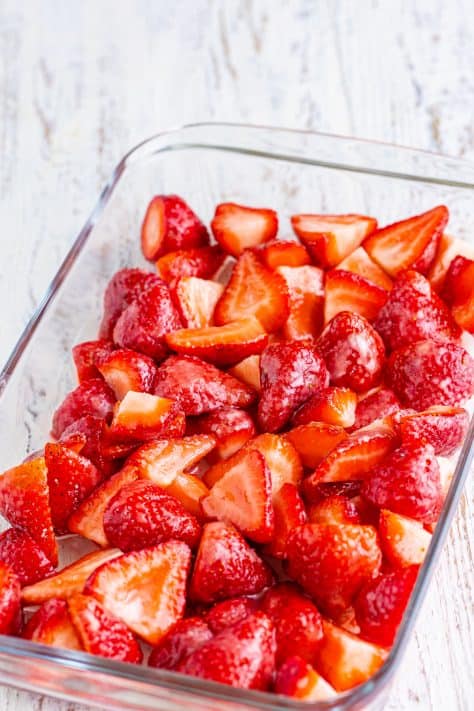 Coated strawberries in a baking dish.