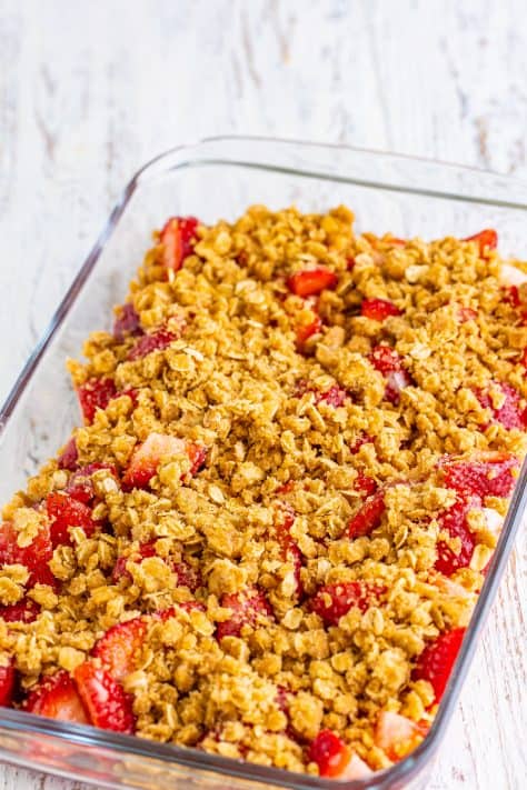 Crumble topping on top of the strawberries in a baking dish.