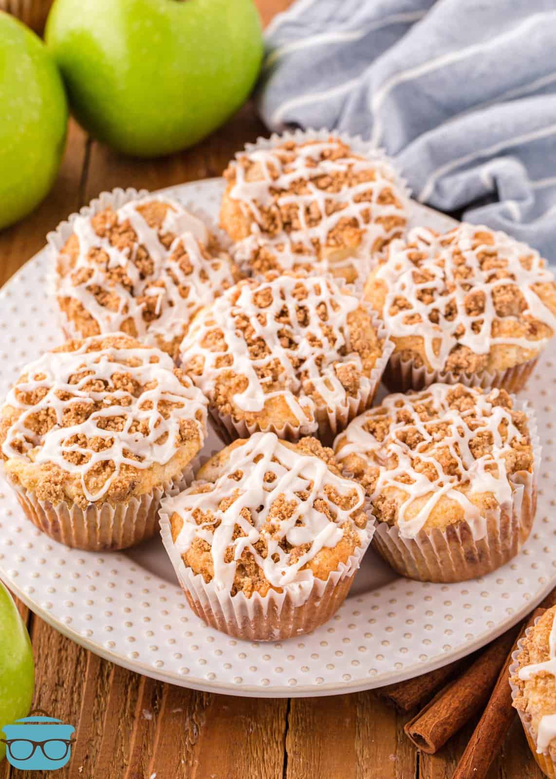 A bunch of fresh made Apple Streusel Muffins on a white plate.