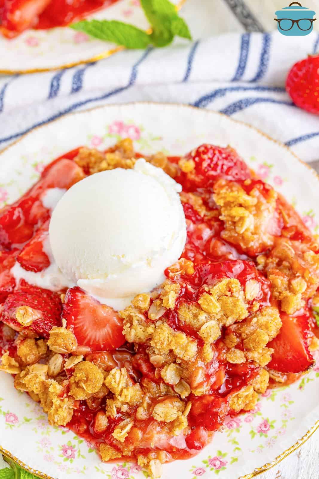 A dessert plate of strawberry crumble with a dollop of ice cream on top.