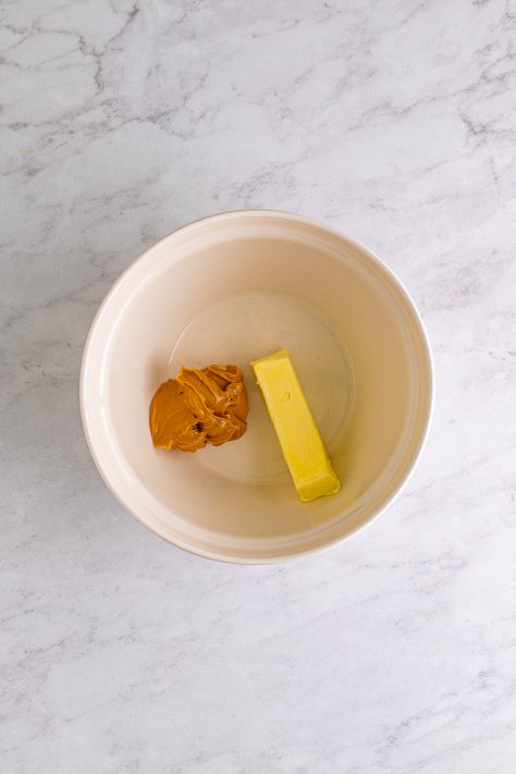 A mixing bowl with butter and peanut butter.