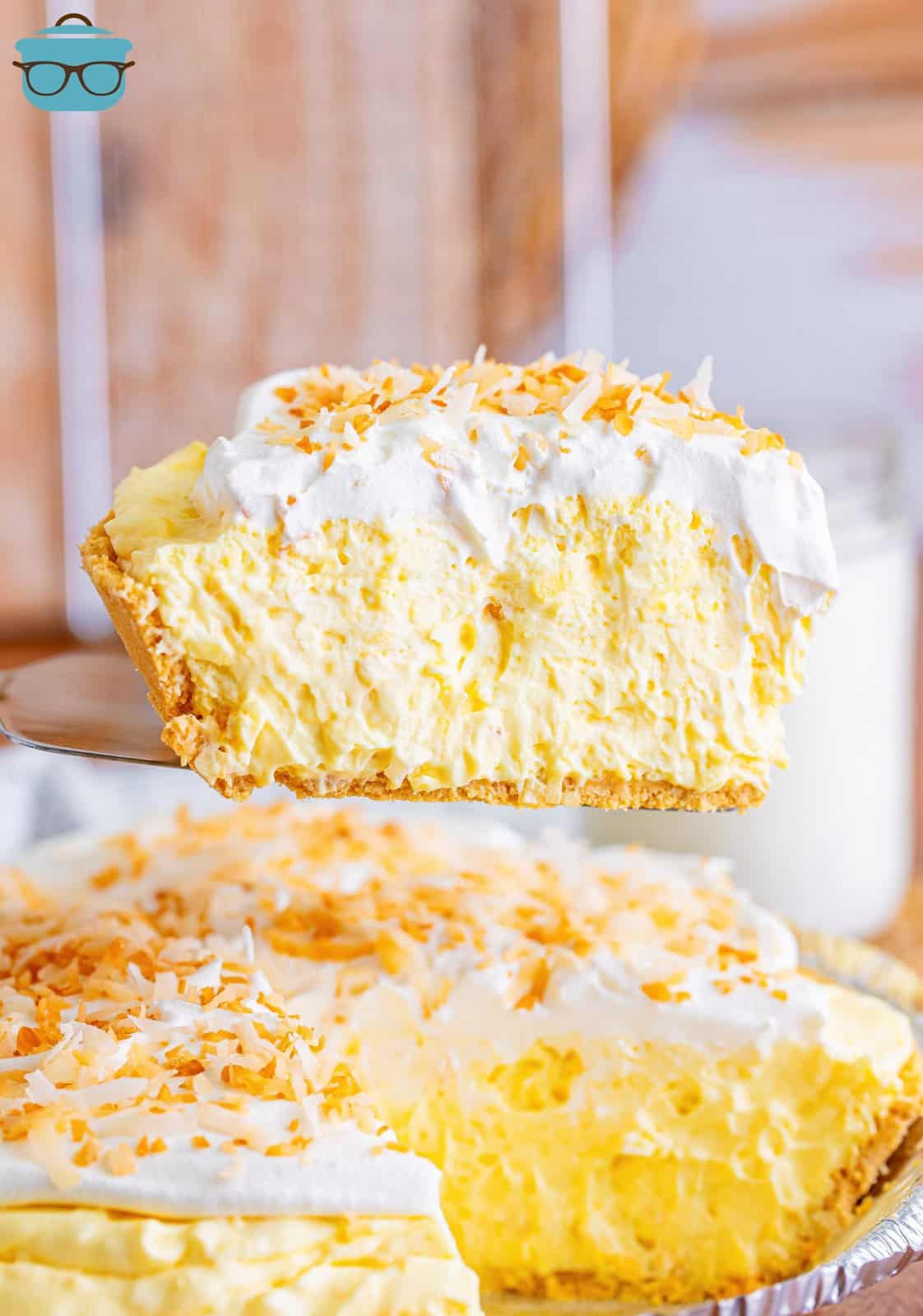 A slice of No Bake Coconut Cream Pie above the rest of the pie.