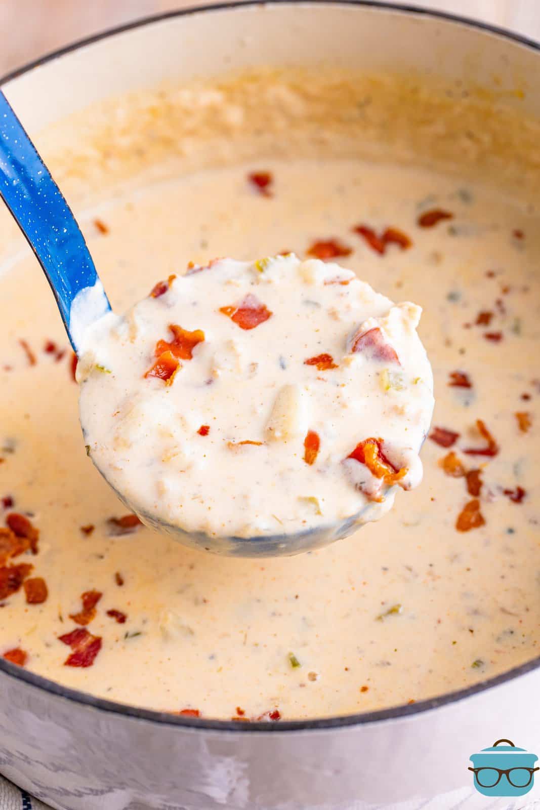 A pot of chowder with a ladle holding a serving above it.