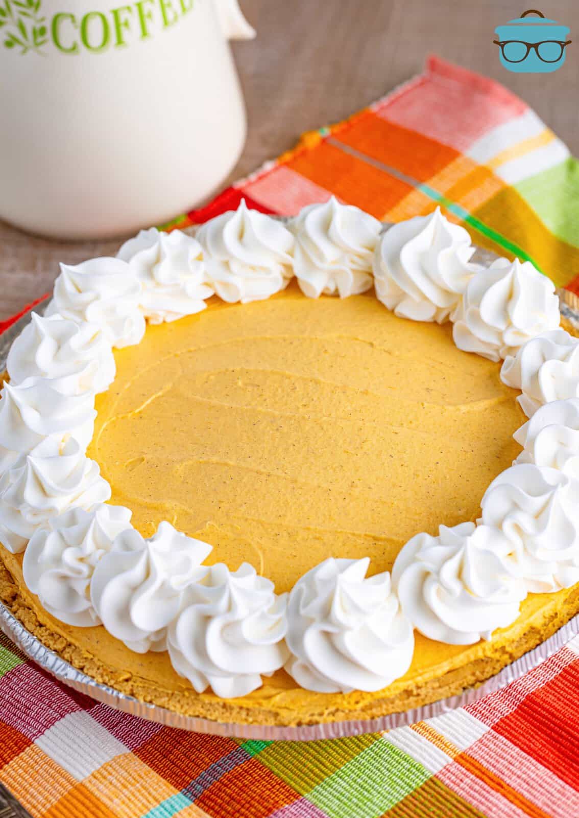 Looking down on a No Bake Pumpkin Cheesecake with whipped cream topping dolloped around.