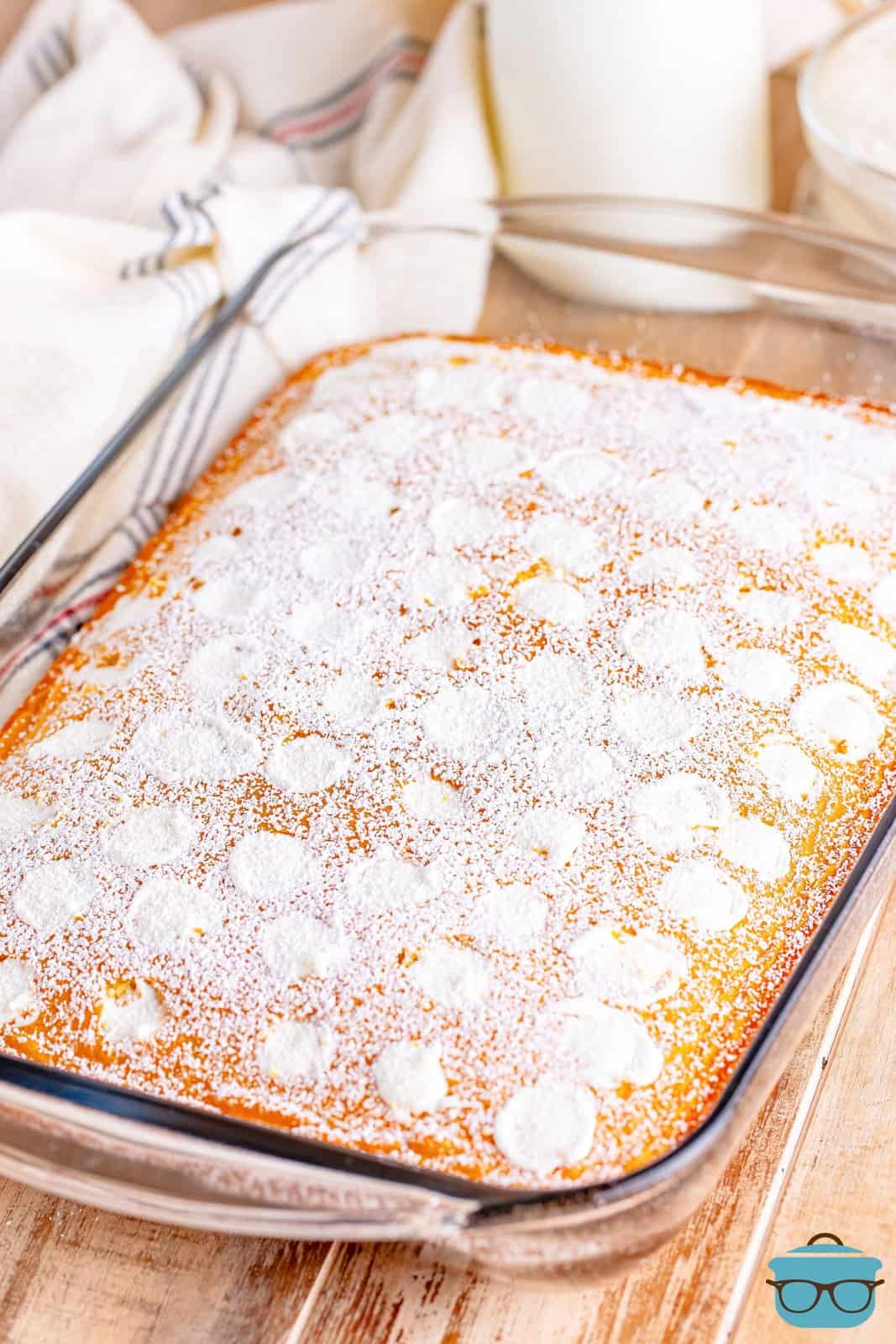 A baking dish with a Twinkie Poke Cake dusted with powdered sugar.