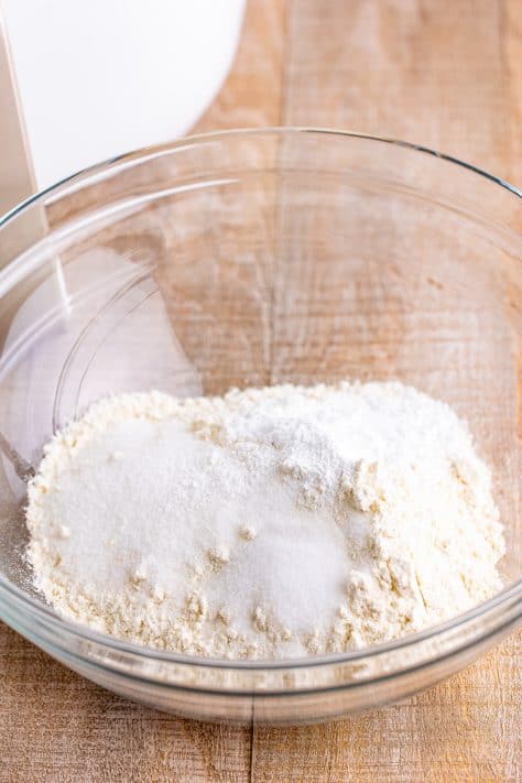 A mixing bowl with e all-purpose flour, granulated sugar, aluminum-free baking powder, and salt.