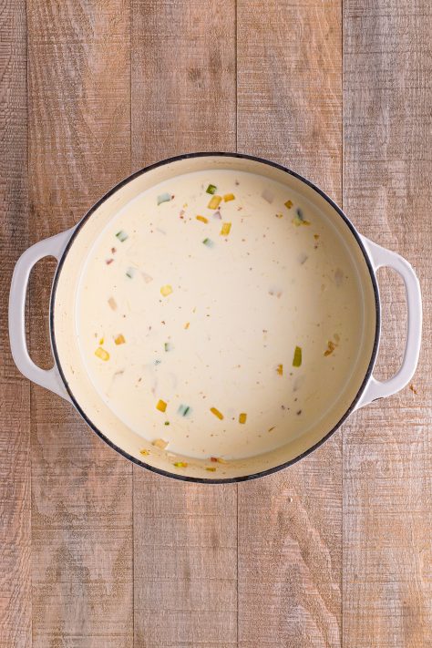 A dutch oven with veggies, flour, stock and heavy cream.