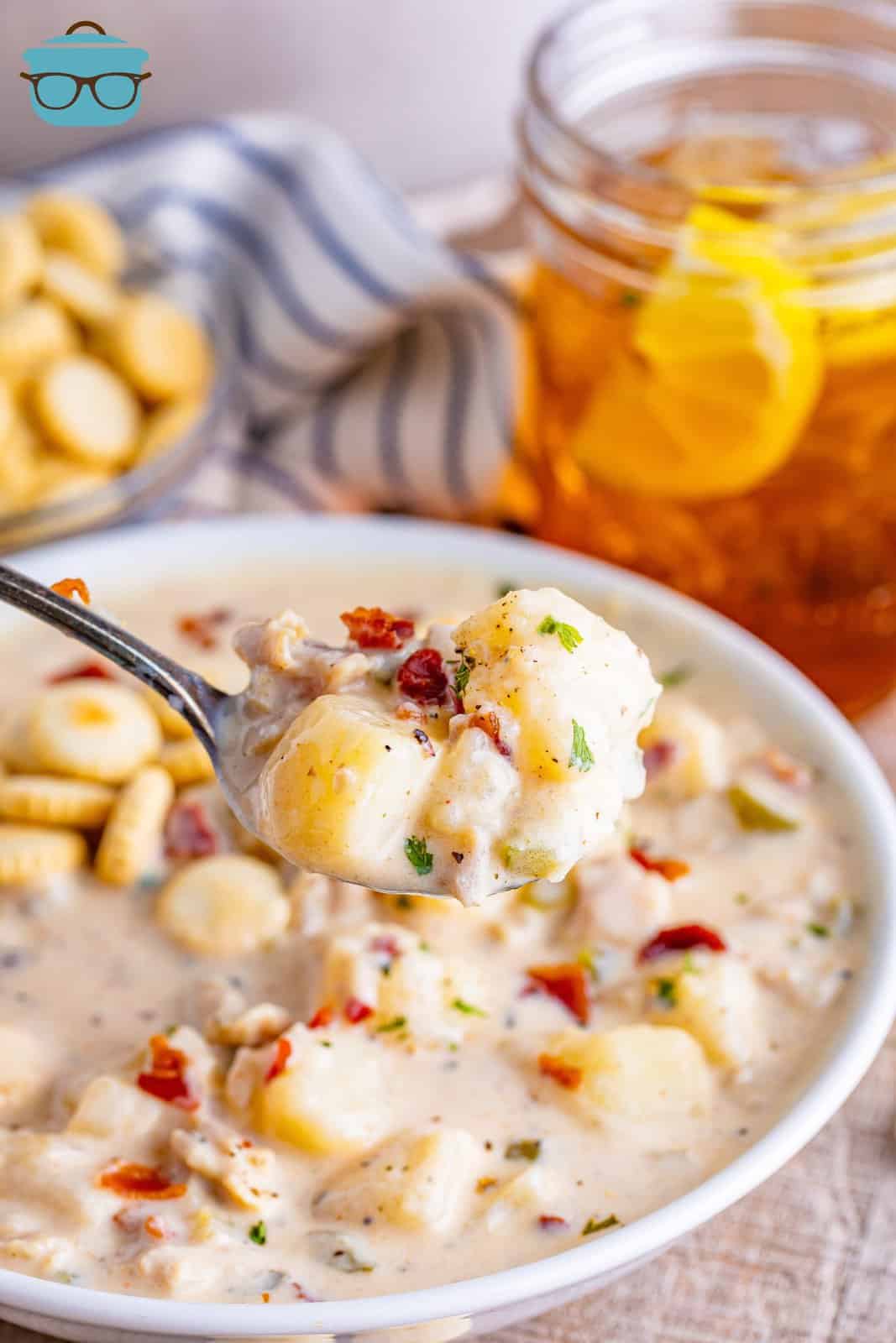 A spoonful of Clam Chowder above the bowl.